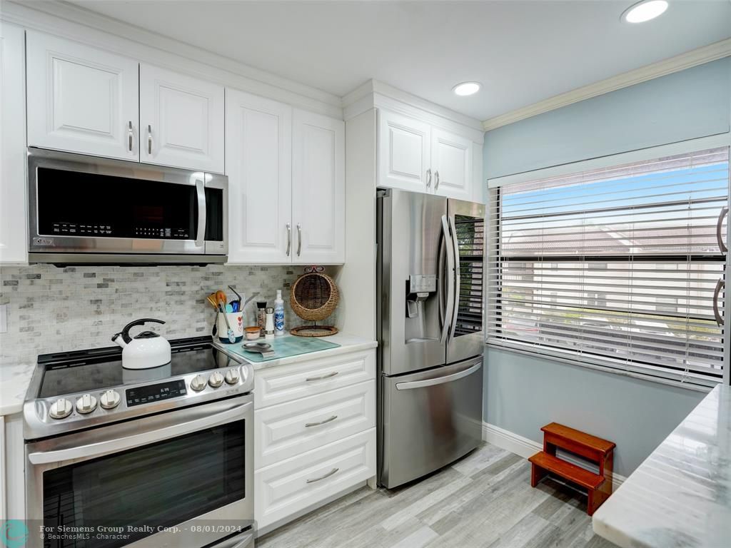 Gorgeous photo showing countertop, cabinets, kitchen appliances