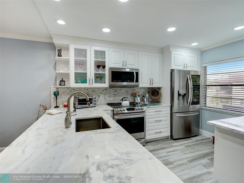 Gorgeous photo showing countertop, cabinets, kitchen appliances